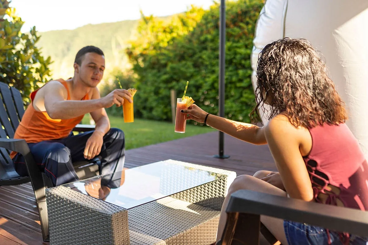 Un couple trinque sur la terrasse de la bulle, au soleil