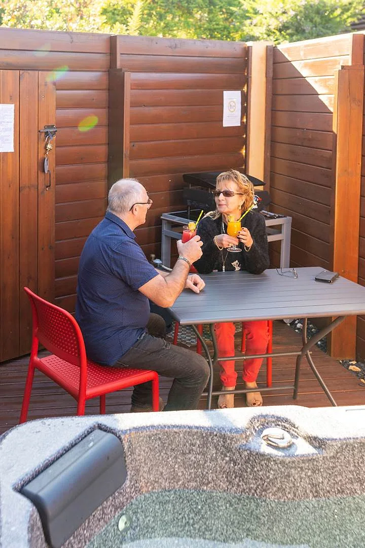 Un couple trinque sur sa terrasse en bois